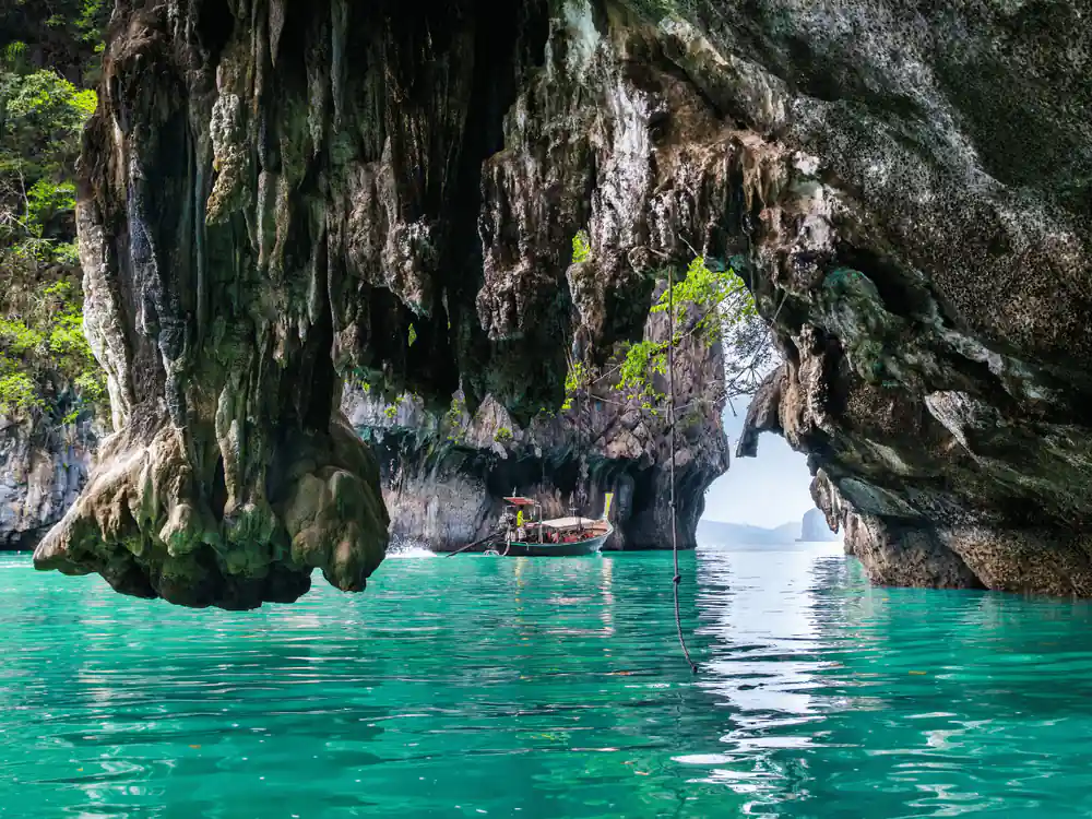 Large cave entrance with turquoise water and small boat