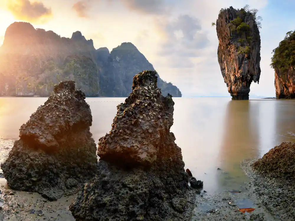 Limestone rock formations in shallow turquoise water at sunset