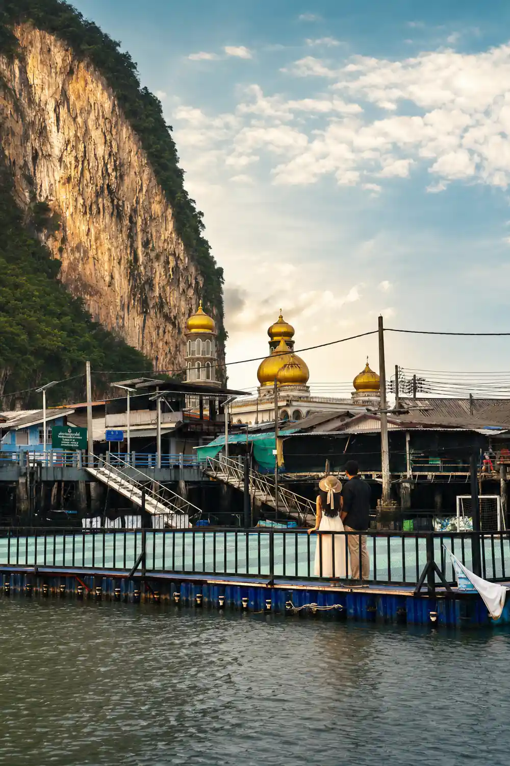 Muslim shrine with golden domes on wooden stilts over water