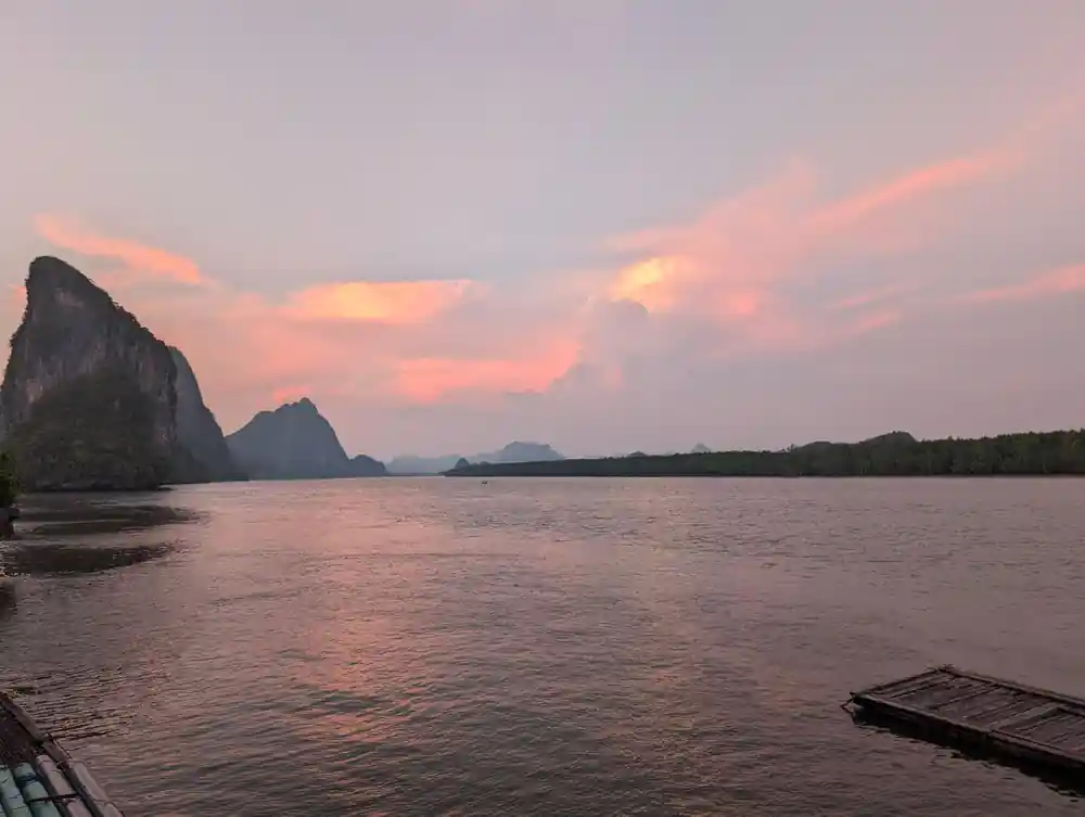 Pink sunset sky over limestone islands and calm water