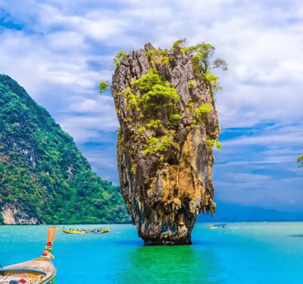 Single limestone pillar with vegetation in blue-green water