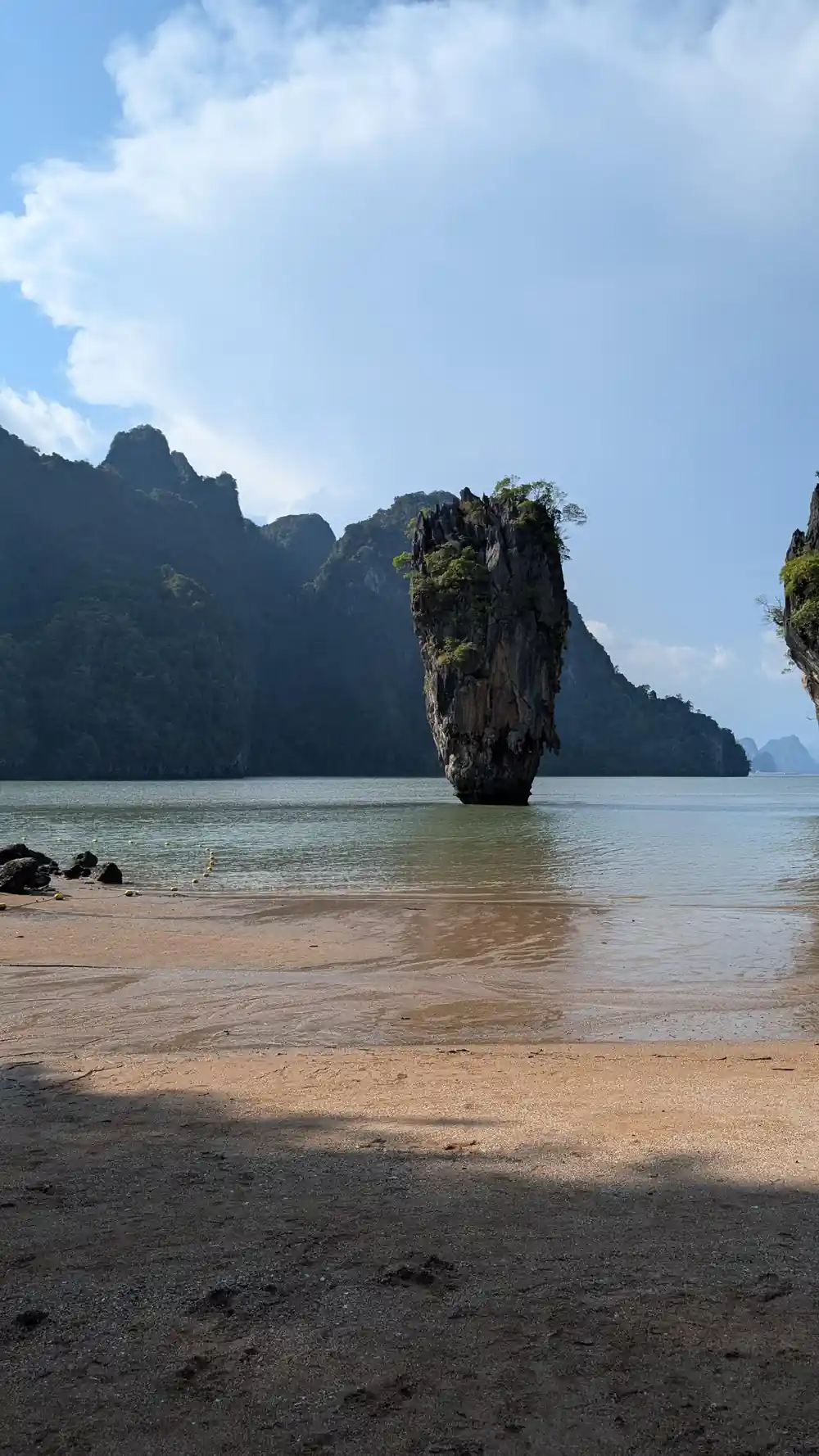 Tall limestone rock formation emerging from shallow water