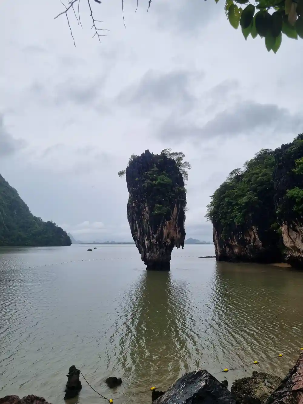 Tall limestone rock formation in shallow turquoise water