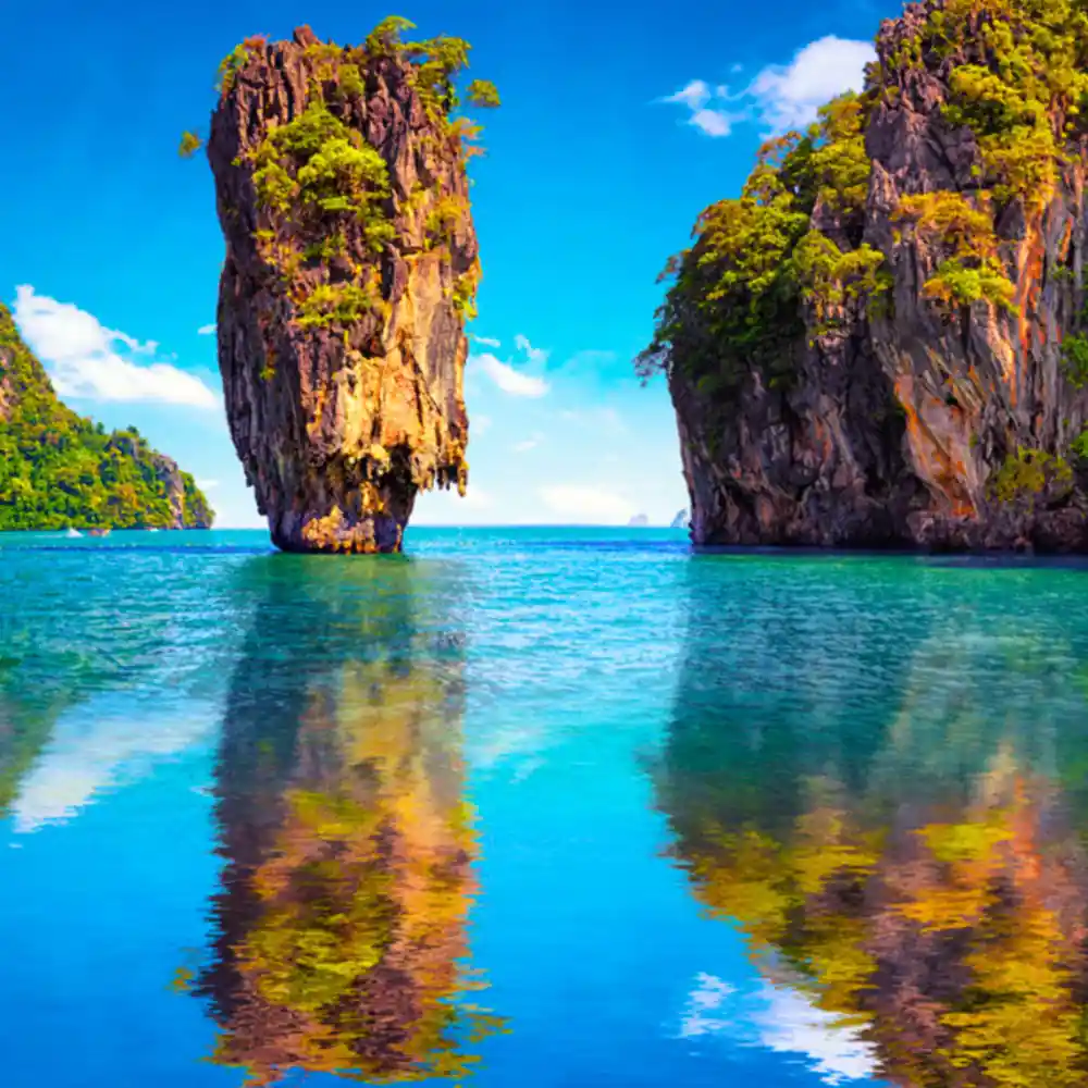 Two tall limestone karst formations reflected in turquoise water