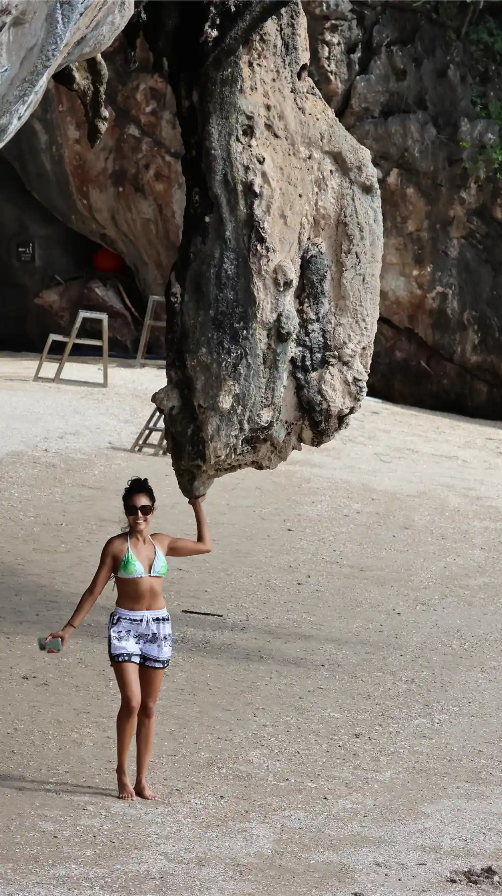 Woman standing under large cave rock formation