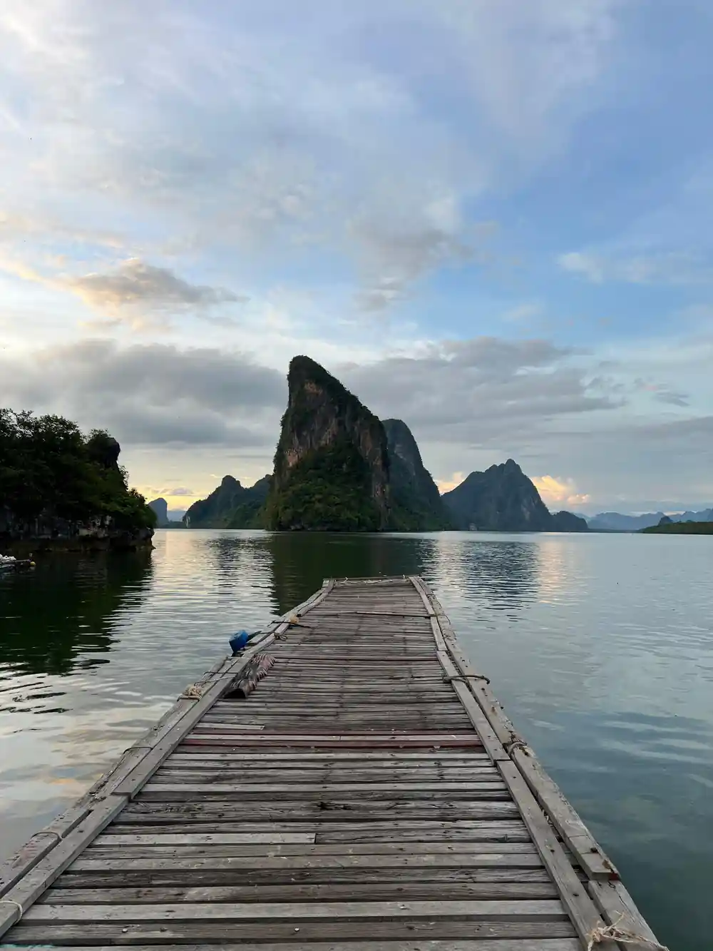 Wooden pier extending toward distant limestone rock formations